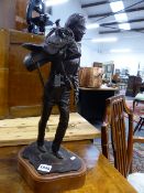 A BRONZE FIGURE OF A COWBOY CARRYING A SADDLE, A SIGNED LIMITED EDITION MODERN CAST ON CONFORMING