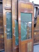 A GROUP OF FOUR ANTIQUE RAILWAY SLIDING DOORS WITH GLAZED PANELS.