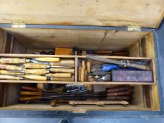 A LARGE VINTAGE CARPENTER'S TOOL CHEST CONTAINING A GOOD SELECTION OF CHISELS, PLANES, SAWS,ETC.