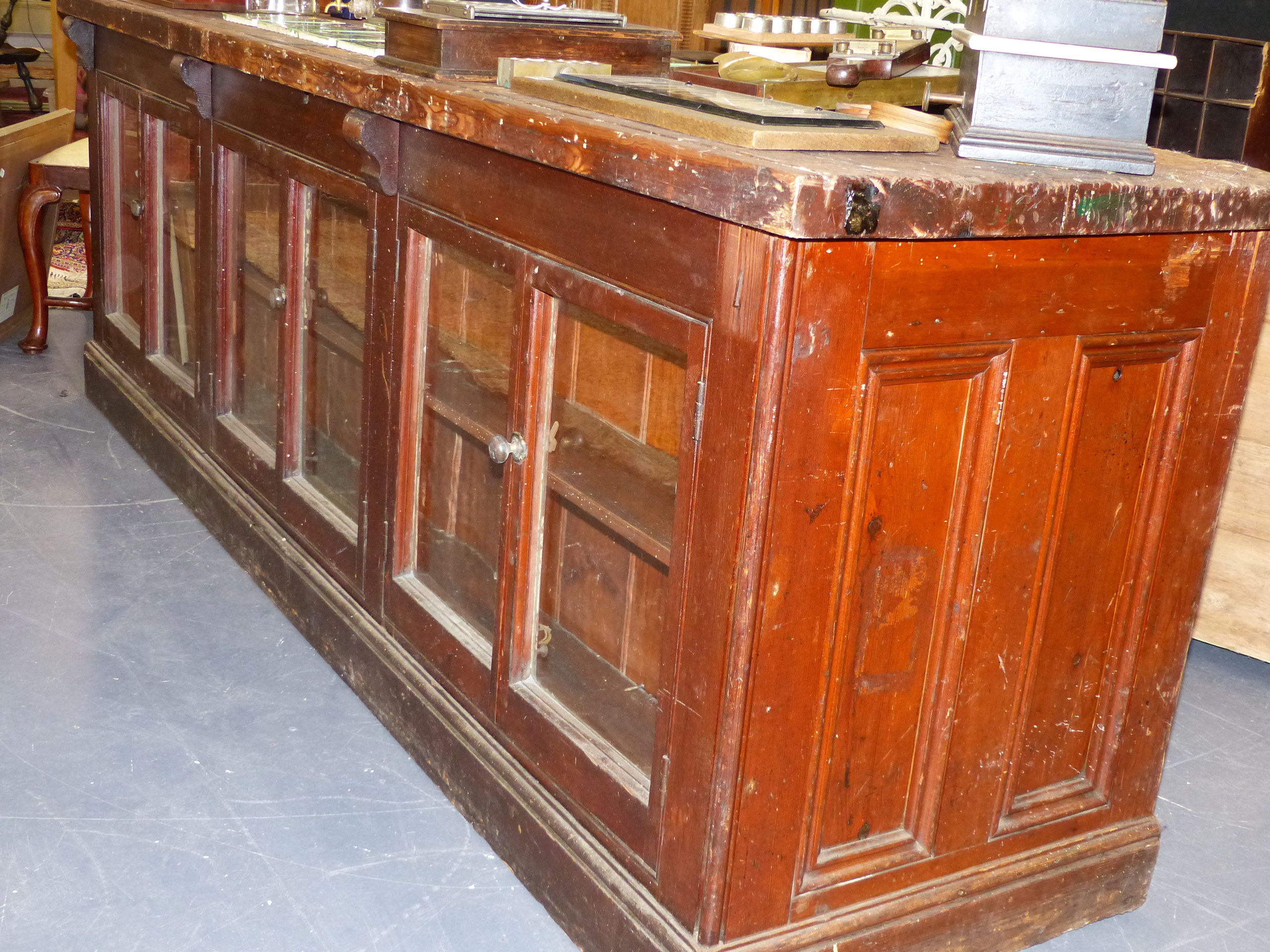 AN ANTIQUE PINE SHOP COUNTER WITH SIX GLAZED PANEL DOORS ENCLOSING SHELVES. W.244 x D.68 x H.83cms. - Image 16 of 16