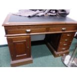 AN ANTIQUE OAK SLOPE TOP PEDESTAL CLERK'S DESK WITH FRIEZE DRAWERS OVER CUPBOARD DOORS. W.120cms.