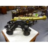 A GOOD PAIR OF ORNAMENTAL BRASS CANNON WITH CAST IRON DRAGON FORM WHEELED CARRIAGES. L.47cms.