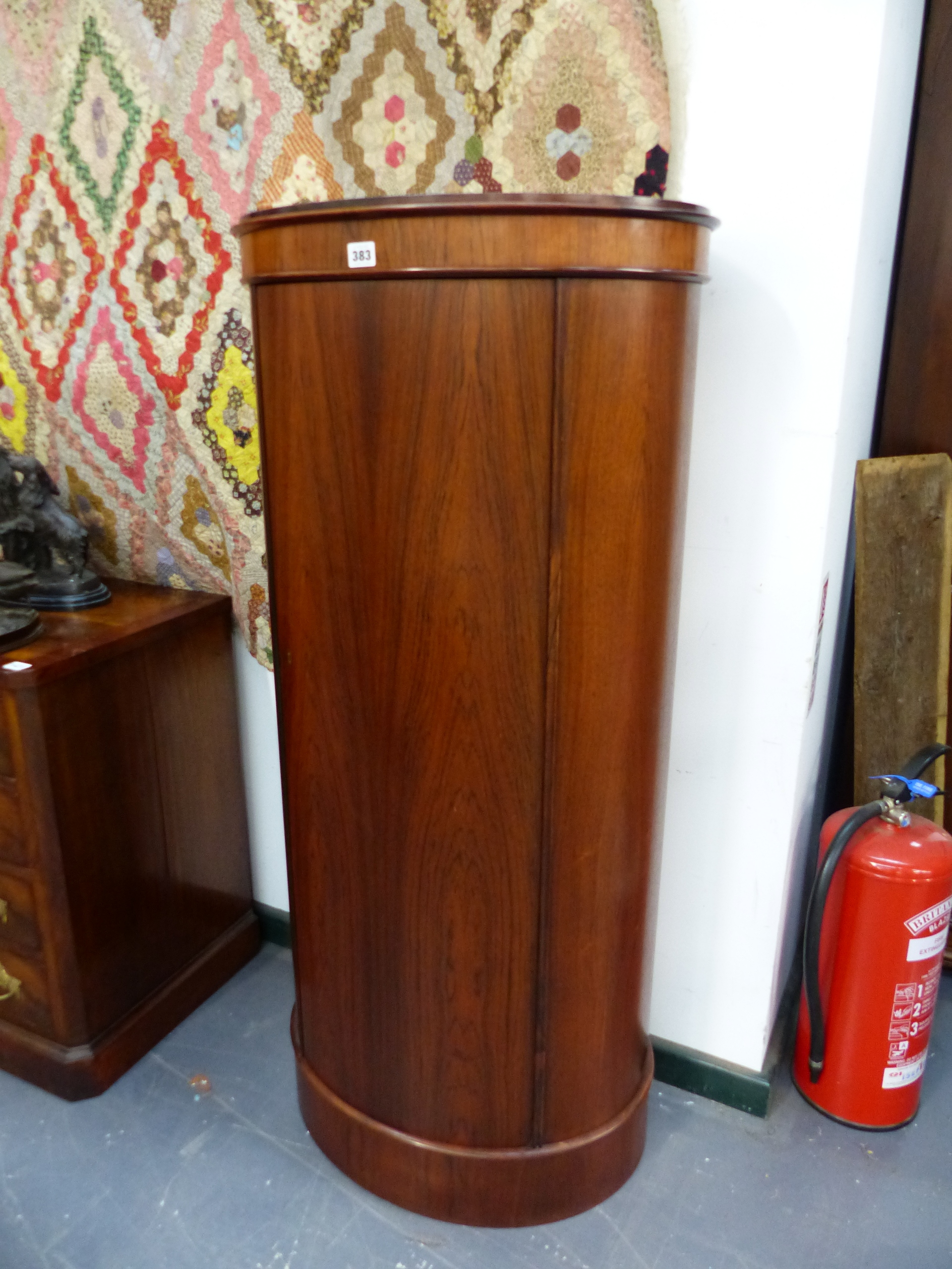 AN INTERESTING SCANDINAVIAN DANISH SANTOS ROSEWOOD OVAL FORM PEDESTAL CABINET WITH SINGLE DOOR.