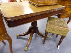 A LATE GEORGIAN MAHOGANY FOLD OVER TEA TABLE ON REEDED COLUMN, QUADRUPED SUPPORTS AND BRASS CASTERS.