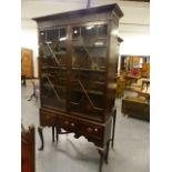 A LARGE ANTIQUE MAHOGANY ASTRAGAL GLAZED BOOKCASE ON A THREE DRAWER CABRIOLE LEG BASE. W.118 x H.