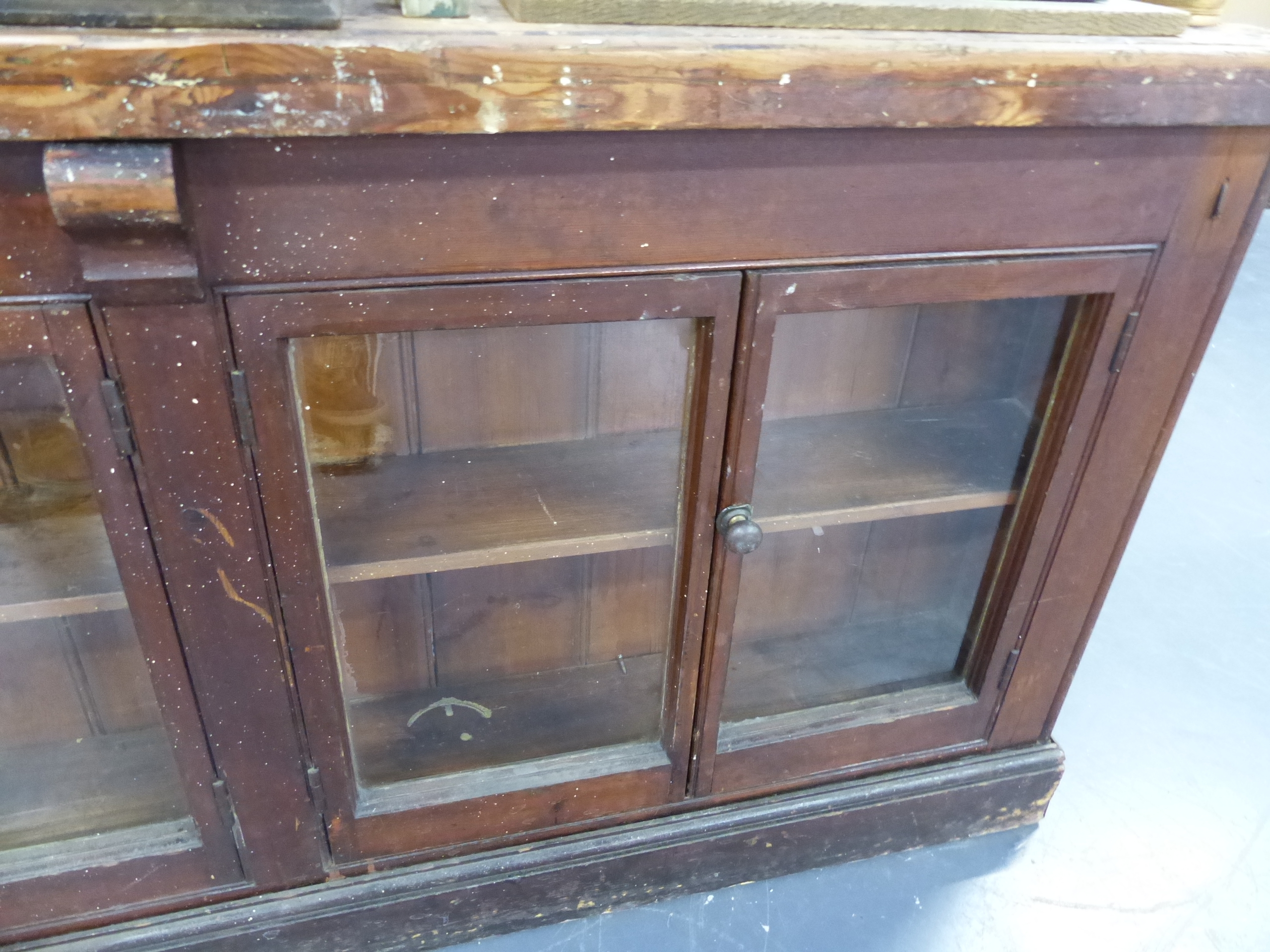 AN ANTIQUE PINE SHOP COUNTER WITH SIX GLAZED PANEL DOORS ENCLOSING SHELVES. W.244 x D.68 x H.83cms. - Image 6 of 16