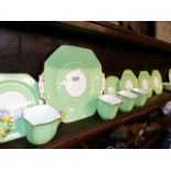 A ROYAL STAFFORD BONE CHINA PART TEA SET DECORATED WITH GREEN BORDERS AND FLORAL HANDLES.