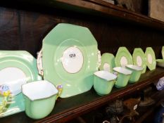 A ROYAL STAFFORD BONE CHINA PART TEA SET DECORATED WITH GREEN BORDERS AND FLORAL HANDLES.