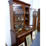 AN EARLY VICTORIAN MAHOGANY BOOKCASE WITH GLAZED DOORS OVER FRIEZE DRAWER AND PANEL DOOR CABINET