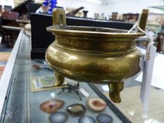 A CHINESE POLISHED BRONZE TWIN HANDLE CENSER WITH ETCHED FIGURAL DECORATION, TRIFID FOOTED AND SIX