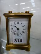 AN EARLY 20th.C.BRASS CASED CARRIAGE CLOCK WITH WHITE ENAMEL DIAL.
