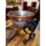 A LARGE COPPER CAULDRON ON WROUGHT IRON STAND.