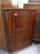 A LATE GEORGIAN OAK CORNER CABINET WITH TWIN PANELLED DOOR. W.65 x H.95cms.