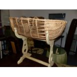 A WICKER CRADLE ON STAND.