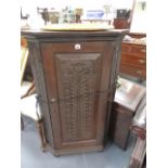 A CARVED OAK CORNER CABINET.