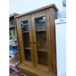 AN OAK GLAZED BOOKCASE CABINET.