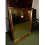 A LARGE GILT FRAMED MIRROR.