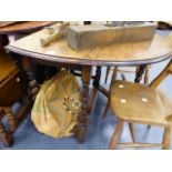 AN OAK BARLEY TWIST GATELEG TABLE AND A LEATHER POOFE.