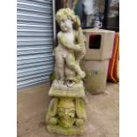 A VINTAGE CARVED STONE FOUNTAIN AND SURROUND SURMOUNTED WITH A FIGURE OF A CHERUB.