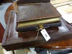 AN ANTIQUE PHOTO ALBUM ON A SELF OPENING DESK STAND TOGETHER WITH A LEATHER BOUND DOCUMENT BOX.