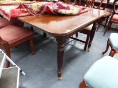 AN IMPRESSIVE ANTIQUE AND LATER MAHOGANY DINING TABLE ON TURNED AND REEDED LEGS WITH BRASS