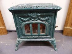 A VINTAGE FRENCH GREEN ENAMEL CAST IRON STOVE WITH PIERCED TOP AND SCROLL LEGS. H.55 x W.55 x D.