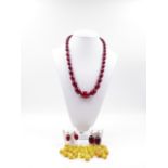 A 30cm GRADUATED STRAND OF CHERRY AMBER BEADS STRUNG ON A WHITE METAL CHAIN, WITH TWO PAIRS OF SCREW