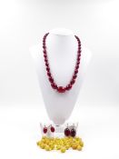 A 30cm GRADUATED STRAND OF CHERRY AMBER BEADS STRUNG ON A WHITE METAL CHAIN, WITH TWO PAIRS OF SCREW