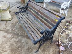 A MODERN GARDEN BENCH WITH CAST IRON ENDS.