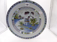 AN EARLY DELFT POTTERY CHARGER WITH PAGODA AND RIVER LANDSCAPE SCENE. Dia.35cms.