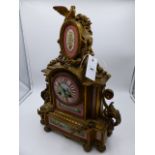 A VICTORIAN GILT METAL CASED MANTLE CLOCK WITH PORCELAIN HANDPAINTED INSET PANELS AND DIAL. 8-DAY