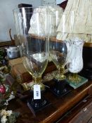 A PAIR OF REGENCY STYLE BRASS MOUNTED BLACK MARBLE CANDLESTICKS WITH CLEAR GLASS STORM SHADES AND