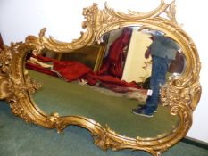 A 19th.C. FRENCH LOUIS XV STYLE GILT CARTOUCHE FORM MIRROR. H.136cms. W.98cms.