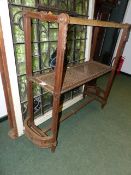 A CARVED OAK FRENCH STAND WITH HANGING RAILS ABOVE CANED UNDERTIER AND D-FORM ENDS. H.125 x W.