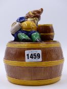 A CONTINENTAL MAJOLICA LIDDED TOBACCO JAR SURMOUNTED BY A SLEEPING BEARDED PEASANT. H.17cms. Dia.