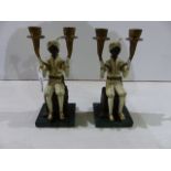 A PAIR OF DECORATED TWIN LIGHT PAINTED BRONZE CANDELABRA IN THE FORM OF SEATED BLACKAMOORS WITH