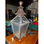 AN ANTIQUE COPPER OUTSIDE LANTERN WITH WALL HANGING BRACKET.