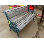 AN ANTIQUE CAST IRON AND TEAK GARDEN BENCH LATER PAINTED GREEN.