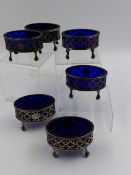 A SET OF SIX GEORGE III OVAL PIERCED SALTS COMPLETE WITH BLUE GLASS LINERS. DATED LONDON 1795.