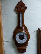 A VICTORIAN OAK CASED ANEROID BAROMETER TOGETHER WITH AN EARLIER MAHOGANY CASED FIVE GLASS BANJO