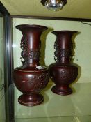 A PAIR OF ORIENTAL BRONZE TWIN HANDLE BALUSTER VASES WITH BIRD AND FLORAL DECORATION. H.34cms.