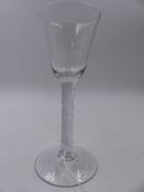 AN EARLY 19th.C. DRINKING GLASS WITH CIRCULAR FOOT AND LATTICED STEM. H.16cms.