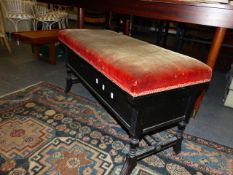 A VICTORIAN AESTHETIC EBONISED BASE DUET PIANO STOOL WITH BOX SEAT. W.96cms.