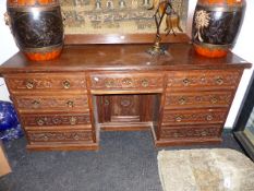 A LARGE LATE VICTORIAN OAK WRITING DESK WITH CARVED OAK DRAWER FRONTS AND SIDE PANELS. W.172 x D.
