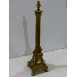 A GILT BRONZE FRENCH EMPIRE STYLE COLUMN FORM LAMP BASE WITH EAGLE CORNER PLINTH RESTING ON PAW