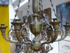 AN ANTIQUE BRASS NEO CLASSICAL STYLE SIX LIGHT CHANDELIER. URN FORM SHAFT WITH SCROLLING BRANCHES.