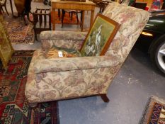 AN EARLY 19th.C.UPHOLSTERED ARMCHAIR ON SHORT TURNED FORELEGS AND BRASS CASTERS.