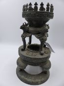 AN ORIENTAL BRONZE STAND OR LAMP BASE WITH MYTHICAL BIRD MASK SUPPORTS. H.30cms.