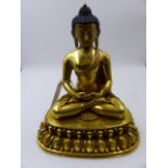 A GILT BRONZE TIBETAN FIGURE OF BUDDHA SEATED ON LOTUS BASE. H.27.5cms.