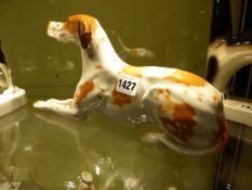 A RUSSIAN PORCELAIN MODEL OF A RECUMBENT HOUND. H.15cms. L.29cms.